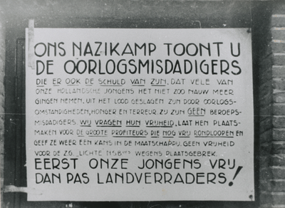 875660 Afbeelding van een pamflet betreffende oorlogsmisdadigers, opgehangen op een deur aan de achterzijde van een ...